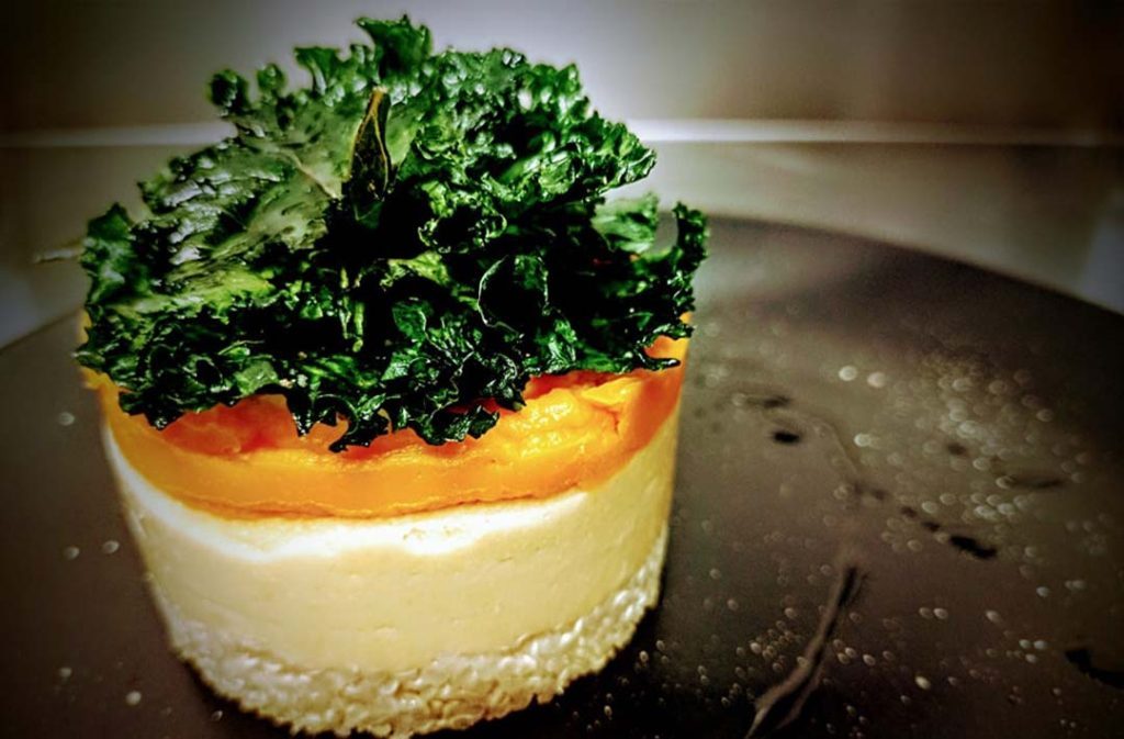 Tortino di ceci e quinoa con crema di zucca e chips di cavolo nero.